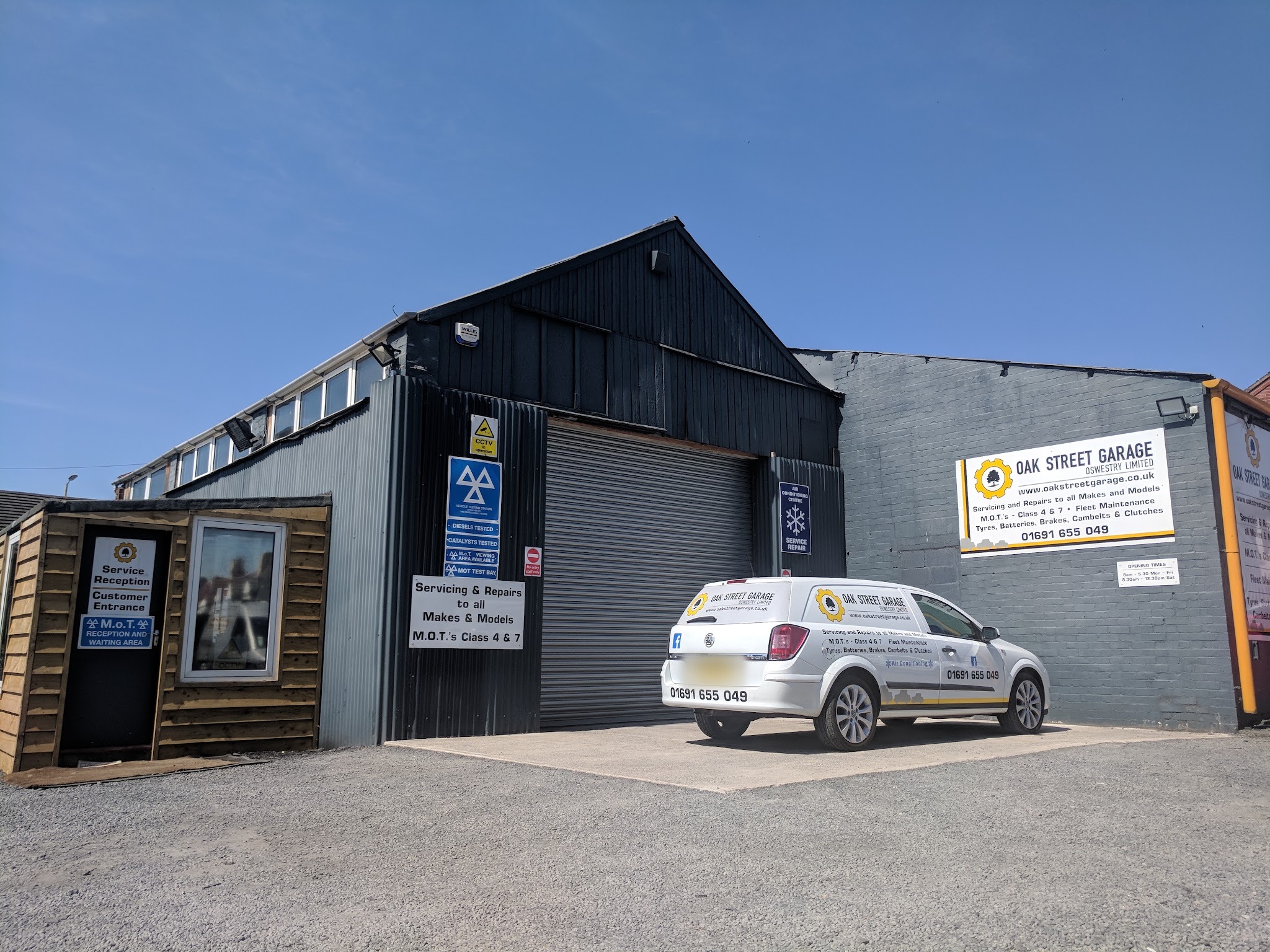 Oak Street Garage under a blue sky, with the branded Oak Street Garage van parked in front of the workshop
